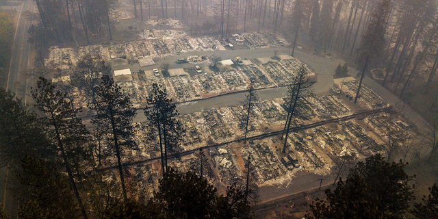 FILE - In this Nov. 15, 2018, file photo, residences leveled by a wildfire line a neighborhood in Paradise, Calif. Mass shootings, hurricanes, fires - for many people across the nation, 2018 was a year of loss unlike any other. As the quintessentially American holiday of Thanksgiving approaches, some will abandon traditions or chose not to mark the holiday at all. Others will celebrate new friendships forged in the wake of tragedy. (AP Photo/Noah Berger, File)