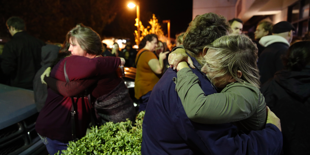 Eva Mills, right, and Holden Grzywacz, two survivors of the Las Vegas mass shooting, mourn the death of Sean Adler during a vigil at the Rivalry Roasters coffee shop Thursday, Nov. 8, 2018, in Simi Valley, Calif. Adler was killed in Wednesday night's shooting at the Borderline Bar and Grill in Thousand Oaks, Calif. (AP Photo/Jae C. Hong)