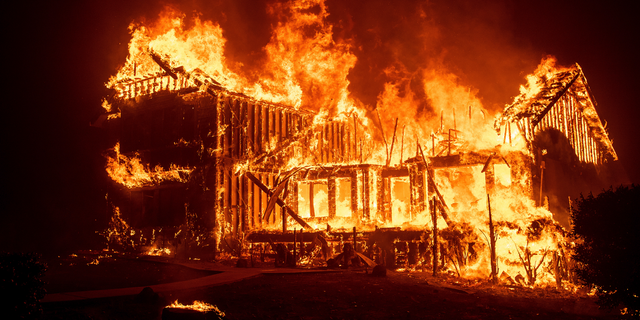 A home burns as the Camp Fire rages through Paradise, Calif., on Thursday, Nov. 8, 2018. Tens of thousands of people fled a fast-moving wildfire Thursday in Northern California, some clutching babies and pets as they abandoned vehicles and struck out on foot ahead of the flames that forced the evacuation of an entire town. (AP Photo/Noah Berger)
