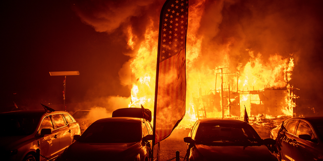 Flames consume a car dealership as the Camp Fire tears through Paradise, Calif., on Thursday, Nov. 8, 2018. Tens of thousands of people fled a fast-moving wildfire Thursday in Northern California, some clutching babies and pets as they abandoned vehicles and struck out on foot ahead of the flames that forced the evacuation of an entire town and destroyed hundreds of structures. (AP Photo/Noah Berger)