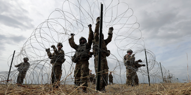 FILE - In this Sunday, Nov. 4, 2018 file photo, members of a U.S Army engineering brigade place concertina wire around an encampment for troops, Department of Defense and U.S. Customs and Border Protection personnel near the U.S.-Mexico International bridge in Donna, Texas. (AP Photo/Eric Gay)