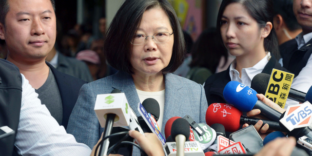 Taiwanese President Tsai Ing-wen, center, speaks to journalists after a vote in local elections in New Taipei City, Taiwan.