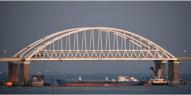 A ship under the the Kerch bridge blocks the passage to the Kerch Strait near Kerch, Crimea, Sunday, Nov. 25, 2018. Ukraine claims it siezed the Russian tanker Wednesday in a move that could put a potential prisoner swap in jeopardy. (AP Photo)