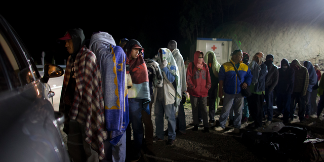 FILE - In this Aug. 31, 2018 file photo, Venezuelan migrants line up for free bread and coffee, donated by a Colombian family from their car, at a gas station in Pamplona, Colombia. On Wednesday, Oct. 31, a work group created by the Organization of American States to focus on Venezuelan migrants said that the organization may ask United States for a benefit similar to Temporary Protective Status to help Venezuelan migrants. (AP Photo/Ariana Cubillos, File)