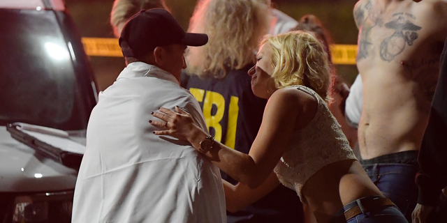 People comfort each other as they stand near the scene Thursday, Nov. 8, 2018, in Thousand Oaks, Calif. where a gunman opened fire Wednesday inside a country dance bar. (AP)
