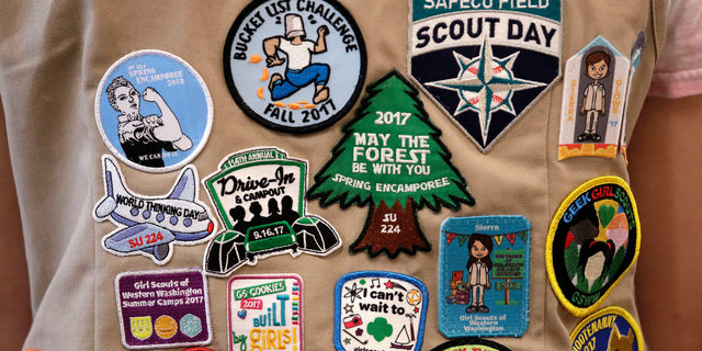 FILE - In this June 18, 2018, file photo, patches cover the back of a Girl Scout's vest at a demonstration of some of their activities in Seattle. The Girl Scouts of the United States of America filed a trademark infringement lawsuit on Monday, Nov. 5, against the Boy Scouts of America for dropping the word "boy" from its flagship program in an effort to attract girls. (AP Photo/Elaine Thompson, File)