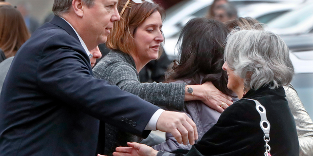 Visitors reach for each other as they gather for the funeral of Rose Mallinger, 97, at Congregation Rodef Shalom on Friday, Nov. 2, 2018, in Pittsburgh. Mallinger was one of the eleven victims killed in the deadly shooting at a synagogue in Pittsburgh's Squirrel Hill neighborhood last Saturday. (AP Photo/Keith Srakocic)