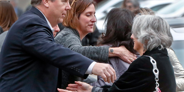 Visitors reach for each other as they gather for the funeral of Rose Mallinger, 97, at Congregation Rodef Shalom on Friday, Nov. 2, 2018, in Pittsburgh. Mallinger was one of the eleven victims killed in the deadly shooting at a synagogue in Pittsburgh's Squirrel Hill neighborhood last Saturday. (AP Photo/Keith Srakocic)