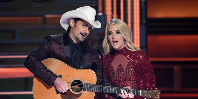 Hosts Brad Paisley, left, and Carrie Underwood during the opening of the 51st annual CMA Awards in Nashville, Tenn. Underwood will be working triple-duty at the 2018 Country Music Association Awards as co-host, performer and nominee. The singer, who is hosting the show alongside Brad Paisley for the 11th time, is pregnant and will hit the stage Wednesday night at the Bridgestone Arena in Nashville, Tennessee.