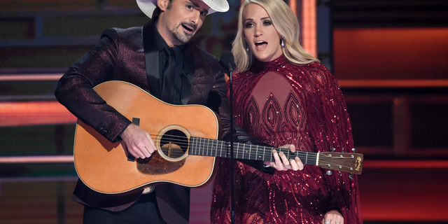 Welcomes Brad Paisley, left, and Carrie Underwood at the opening of the 51st annual CMA Awards in Nashville, Tennessee. Underwood will be working on the 2018 Country Music Association Awards as a co-host, performer and nominee. The singer, who hosts the show alongside Brad Paisley for the 11th time, is pregnant and will be on the stage Wednesday night at the Bridgestone Arena in Nashville, Tennessee.