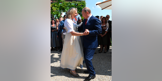 FILE -- In this Saturday, Aug. 18, 2018 photo Russian President Vladimir Putin, right, dances with Austrian Foreign Minister Karin Kneissl as he attends the wedding of Kneissl with Austrian businessman Wolfgang Meilinger in Gamlitz, southern Austria. (Roland Schlager/Pool photo via AP)