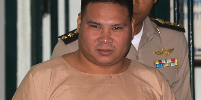 FILE - In this Thursday, March 3, 2016, file photo, Vivat Yodprasit, the "Popcorn Gunman," is escorted by Thai correctional officers while arriving at Criminal court in Bangkok, Thailand. Thailand's Supreme Court has restored the 37-year prison term given to Vivat after he was convicted of shooting four people during a 2014 political melee. (AP Photo/Sakchai Lalit, File)