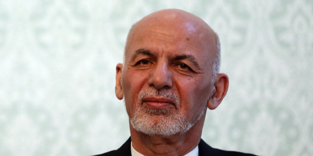 FILE - IN this Nov. 6, 2018, photo, Afghan President Ashraf Ghani, listens during a news conference with NATO Secretary General Jens Stoltenberg, at the presidential palace, in Kabul, Afghanistan. Ghani is denying the Taliban is winning the war in Afghanistan despite a continuing wave of deadly militant attacks and signs the militants are expanding areas under their control. Ghani said the Afghan state is not at risk of collapse and reiterated his government's intent to seek a negotiated peace. Ghani was speaking by video to an audience in Washington. (AP Photo/Massoud Hossaini)