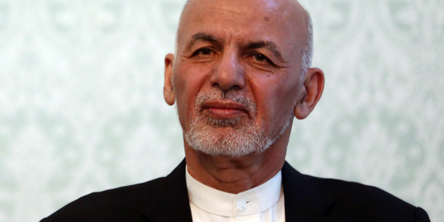 FILE - IN this Nov. 6, 2018, photo, Afghan President Ashraf Ghani, listens during a news conference with NATO Secretary General Jens Stoltenberg, at the presidential palace, in Kabul, Afghanistan. Ghani is denying the Taliban is winning the war in Afghanistan despite a continuing wave of deadly militant attacks and signs the militants are expanding areas under their control. Ghani said the Afghan state is not at risk of collapse and reiterated his government's intent to seek a negotiated peace. Ghani was speaking by video to an audience in Washington. (AP Photo/Massoud Hossaini)