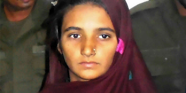 FILE - In this Monday, Oct. 30, 2017, file photo, Aasia Bibi is presented to journalists at a police station in Muzaffargarh, Pakistan. Bibi was acquitted in Pakistan, Thursday, Nov. 8, 2018, after eight years on death row for blasphemy. Those familiar with her whereabouts say she is still in Pakistan. (AP Photo/Iram Asim, File)