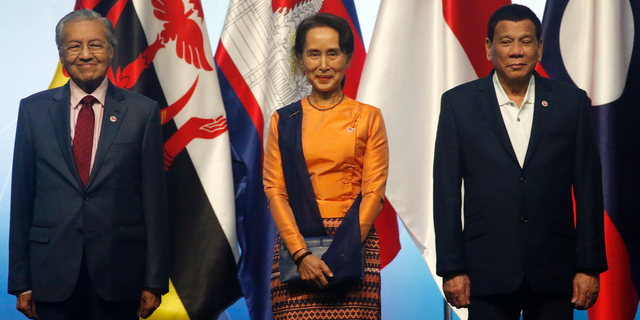 ASEAN Leaders pose for a family photo during the opening ceremony for the 33rd ASEAN Summit and Related Summits Tuesday, Nov. 13, 2018, in Singapore. From left; Prime Minister Mahathir Mohamad of Malaysia, Myanmar Leader Aung San Suu Kyi, President Rodrigo Duterte of The Philippines. (AP Photo/Bullit Marquez)