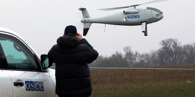 FILE - In this Thursday, Oct. 23, 2014 file photo, a member of the Organization for Security and Co-operation in Europe (OSCE) mission to Ukraine watches a drone take off during a test flight near the town of Mariupol, eastern Ukraine. Germany and France say it appears that Russian-backed separatists in Ukraine downed a drone being used by neutral European observers and are demanding accountability. In a joint statement, they said Thursday, Nov. 1, 2018 the downing is a "clear violation" of the Organization for Security and Cooperation in Europe's Special Monitoring Mission in Ukraine, which is to have unimpeded access. (AP Photo/Dmitry Lovetsky, file)