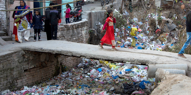 FILE - In this Dec. 25, 2016, file photo, a Pakistani Christian girl crosses a bridge in poor Christian neighborhood in Islamabad, Pakistan.The uproar surrounding Aasia Bibi _ a Pakistani Christian woman who was acquitted of blasphemy charges and released from death row but remains in isolation for her protection _ has drawn attention to the plight of the country's Christians.The minority, among Pakistan's poorest, has faced an increasingly intolerant atmosphere in this Muslim-majority nation where radical religious and sectarian groups have become more prominent in recent years. (AP Photo/B.K. Bangash, File)