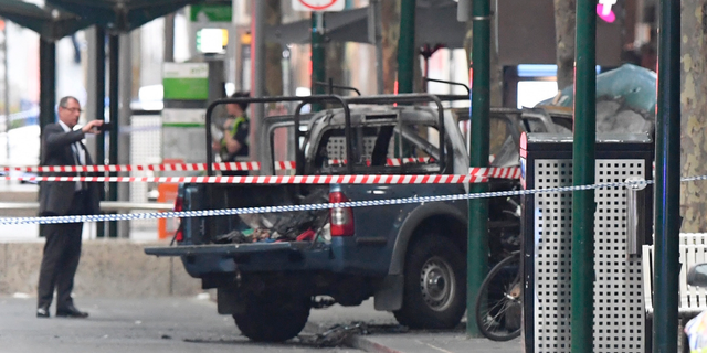 A burnt out vehicle is seen on Bourke Street in Melbourne, Friday, Nov. 9, 2018. A knife-wielding man stabbed two people, one fatally, in Australia's second-largest city on Friday in an attack likely linked to terrorism, police said. The attack during the afternoon rush hour brought central Melbourne to a standstill.(James Ross/AAP Image via AP)