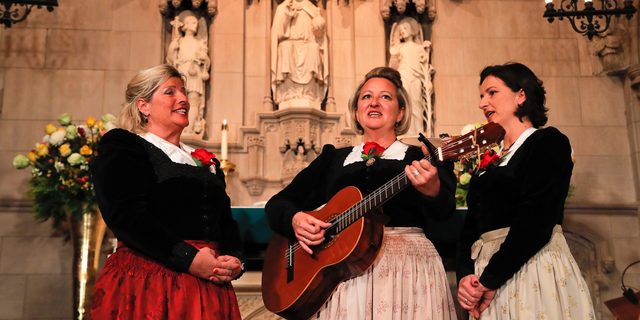 The Kroell Family Singers, Gerlinde, left, Elisabeth, center, and Christiane, sing Christmas Carols during a celebration of the song "Silent Night," at Trinity Church, Tuesday, Nov. 27, 2018, in New York. (AP Photo/Julie Jacobson)