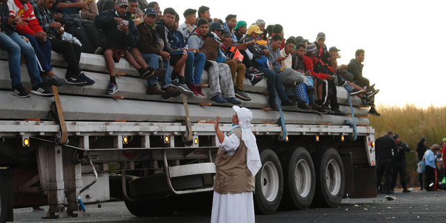 A Catholic nun gives travel advice to Central American migrants riding in the bed of a semi-trailer, as they move toward the U.S. border, in Ixtlán del Rio, Nayarit, Mexico, Tuesday, Nov. 13, 2018. The U.S. government said it was starting work Tuesday to "harden" the border crossing from Tijuana, Mexico, to prepare for the arrival of a migrant caravan leapfrogging its way across western Mexico. (AP Photo/Marco Ugarte)