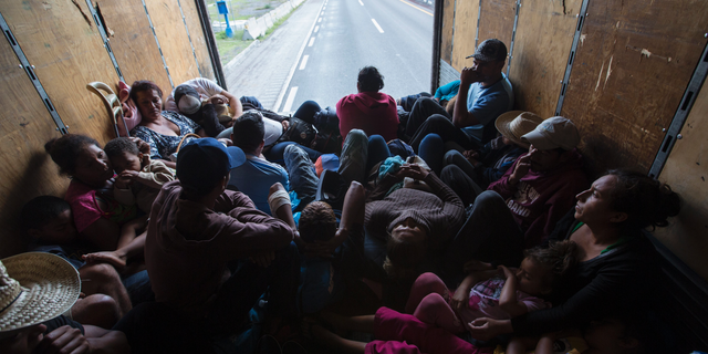 U.S.-bound Central American migrants begin their morning trek with a free ride in the back of a truck as they leave Cordoba, Veracruz state, Mexico, Monday, Nov. 5, 2018. A big group of Central Americans pushed on toward Mexico City from a coastal state Monday, planning to exit a part of the country that has long been treacherous for migrants seeking to get to the United States. (AP Photo/Rodrigo Abd)