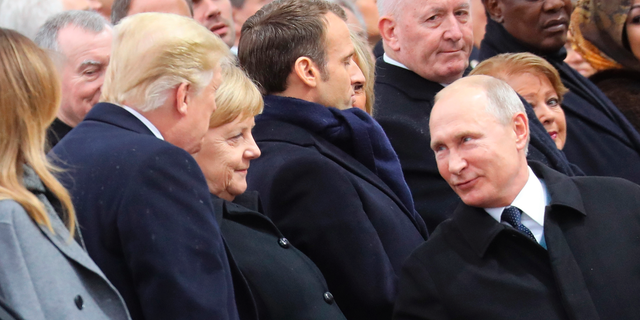 Russian President Vladimir Putin talks with German Chancellor Angela Merkel and US President Donald Trump as they attend a ceremony at the Arc de Triomphe in Paris, as part of commemorations marking the 100th anniversary of the 11 November 1918 armistice, ending World War I, Sunday, Nov. 11, 2018. (Ludovic Marin/Pool Photo via AP)