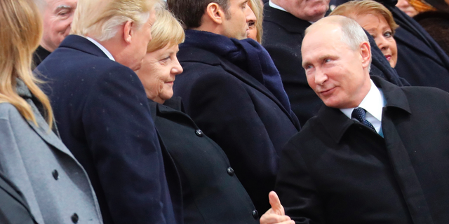 Russian President Vladimir Putin talks with German Chancellor Angela Merkel and US President Donald Trump as they attend a ceremony at the Arc de Triomphe in Paris, as part of commemorations marking the 100th anniversary of the 11 November 1918 armistice, ending World War I, Sunday, Nov. 11, 2018. (Ludovic Marin/Pool Photo via AP)