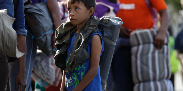 Young Honduran migrant Daniel Gamez waits with his family in a line for a meal after arriving with the Central America migrant caravan in Tijuana, Mexico, Thursday, Nov. 15, 2018. Members of a migrant caravan started to meet some local resistance as they continued to arrive by the hundreds in the Mexican border city of Tijuana, where a group of residents clashed with migrants camped out by the U.S. border fence. (AP Photo/Gregory Bull)