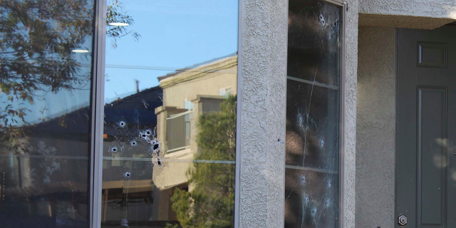 Bullet holes mark the windows of a house that was hit by gunfire Thursday night, killing an 11-year-old girl in North Las Vegas, Friday, Nov. 2, 2018. An armed group intent on gang-related retaliation opened fire on the wrong house in suburban Las Vegas, killing the girl in her kitchen, police said Friday. (Max Michor/Las Vegas Review-Journal via AP)