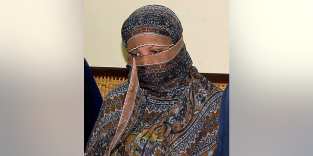 FILE - In this Nov. 20, 2010, file photo, Asia Bibi, a Pakistani Christian woman, listens to officials at a prison in Sheikhupura near Lahore, Pakistan. Italy is working to help relocate the family of a Pakistani Christian woman acquitted eight years after being sentenced to death for blasphemy, amid warnings from her husband that their life is in danger in Pakistan. (AP Photo, File)