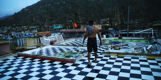 FILE - In this Sept. 26, 2017 file photo, Nestor Serrano walks on the upstairs floor of his home, where the walls were blown off, in the aftermath of Hurricane Maria, in Yabucoa, Puerto Rico. More than a year after Hurricane Maria caught Puerto Rico's government wildly unprepared, officials acknowledge they still haven't come up with a plan to cope with the next such disaster and it's not clear when they will. (AP Photo/Gerald Herbert, File)