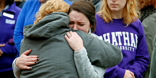 Chatham University students hug during a visit Thursday, Nov. 1, 2018, to a makeshift memorial outside the Tree of Life synagogue dedicated to the 11 people killed Oct. 27 while worshipping, in the Squirrel Hill neighborhood of Pittsburgh. (AP Photo/Gene J. Puskar)