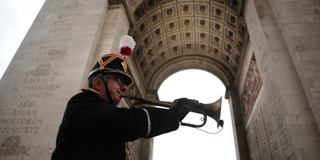 Military officer Garcia plays the original Armistice bugle from 1918 under the Arc de Triomphe Sunday, Nov. 11, 2018 in Paris. More than 60 heads of state and government are in France for the Armistice ceremonies at the Tomb of the Unknown Soldier in Paris on the 11th hour of the 11th day of the 11th month, exactly a century after the armistice. (AP Photo/Francois Mori, Pool)