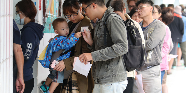 Voters line up at a ballot station to vote for the city mayor in Kaohsiung, Taiwan, Saturday, Nov. 24, 2018. Taiwanese began voting in midterm local elections Saturday seen as a referendum on the independence-leaning administration of President Tsai Ing-wen, amid growing pressure from the island's powerful rival China. (AP Photo)