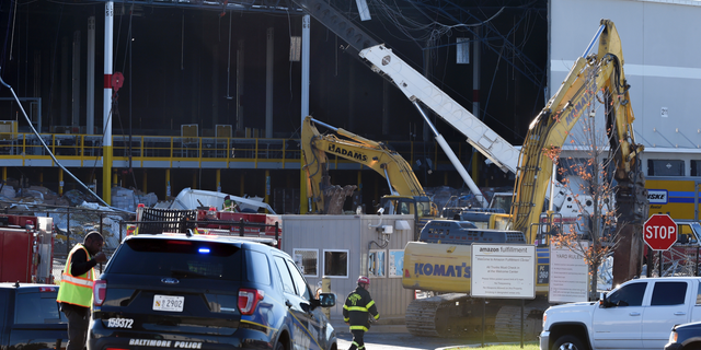 Emergency personnel look over damage, Saturday, Nov. 3, 2018, after a weather-related building collapse at an Amazon distribution warehouse on Baltimore's southeast side Friday night. Chief Roman Clark tells the Sun that a 50-foot wall collapsed late Friday at the Amazon Fulfillment Center as a storm hit the area. (Ulysses Munoz/The Baltimore Sun via AP)