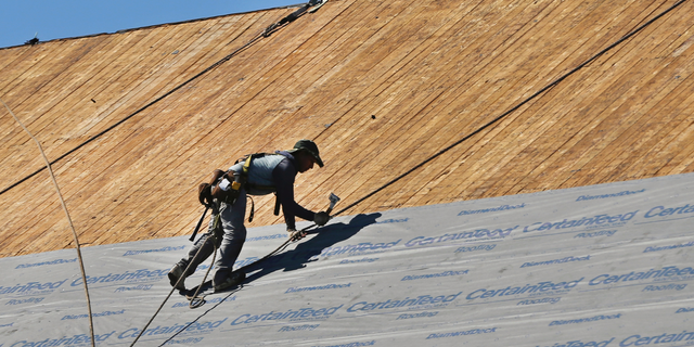FILE- In this July 19, 2018, file photo a roofer works on top of the church at St. Lucy Parish in Methuen, Mass. On Monday, Nov. 5, the Institute for Supply Management, a trade group of purchasing managers, issues its index of non-manufacturing activity for September. (AP Photo/Elise Amendola, File)