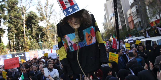 An effigy of U.S. government icon "Uncle Sam" is held up by demonstrators during a rally in front of the former U.S. Embassy in Tehran, Iran, on Sunday, (AP Photo/Vahid Salemi)