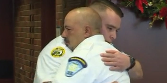 EMT partners Chris Cabral and Ray Berwick embrace at a ceremony celebrating Berwick's actions that helped save Cabral following his stroke.