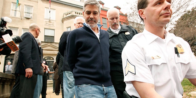 Actor George Clooney is arrested for civil disobedience after protesting at the Sudan Embassy in Washington on March 16, 2012. Clooney was protesting the escalating humanitarian crisis in Sudan. REUTERS/Kevin Lamarque (