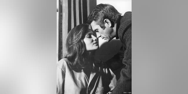 Jacqueline Bisset leans forward to kiss Steve McQueen in a scene from the film "Bullitt." — Getty