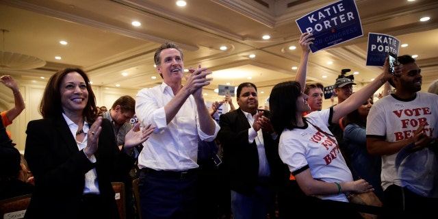 Sen. Kamala Harris, D-Calif., left, and California gubernatorial Democratic candidate Gavin Newsom applaud as they listen to Katie Porter, a congressional candidate for California's 45th District, during a campaign rally Saturday, Nov. 3, 2018, in Irvine, Calif. The fight for control of the U.S. House is attracting big names to historically Republican Orange County, California. (AP Photo/Jae C. Hong)