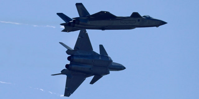 Two J-20 stealth fighter jets of the Chinese People's Liberation Army (PLA) Air Force perform during the 12th China International Aviation and Aerospace Exhibition.