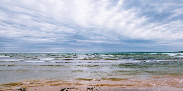 A man died and a woman remains missing Monday after they encountered hazardous conditions while swimming in Lake Michigan, officials said.