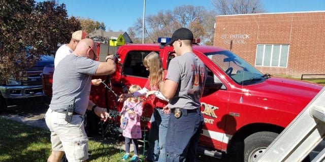 The McCook Fire Department gathered to help the family of Raleigh Haas put up Raleigh's Christmas lights.