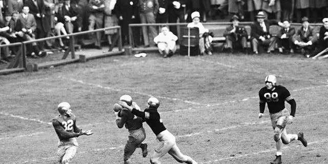 FILE - In this Nov. 9, 1946, file photo, Notre Dame's Emil Sitko grabs a pass intended for Army's Bill West, center right, during the fourth quarter of a college football game at Yankee Stadium in New York.