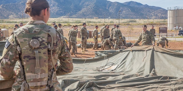 U.S. Army soldiers, assigned to 309th Military Intelligence Battalion and 305th Military Intelligence Battalion, positioning a tent on Fort Huachuca, Arizona.