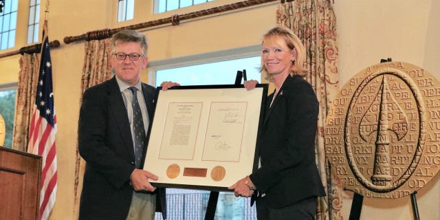 Charles Pinck presented a replica of the O.S.S. Congressional Gold Medal that the society received earlier this year to Congressional Country Club president, Bev Lane, in a recent ceremony, which also honored the veterans taking part in the PGA Hope program. (Courtesy of Dr. Ed Gwozdz)