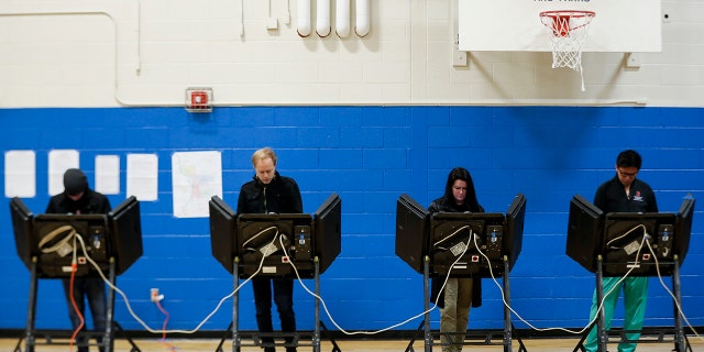 Across the country, voters headed to the polls Tuesday in one of the most high-profile midterm elections in years. (AP Photo/John Minchillo)
