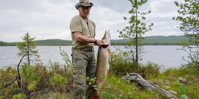 Russia's President Vladimir Putin poses for a picture as he fishes in the Krasnoyarsk territory in the Siberian Federal District July 20, 2013.